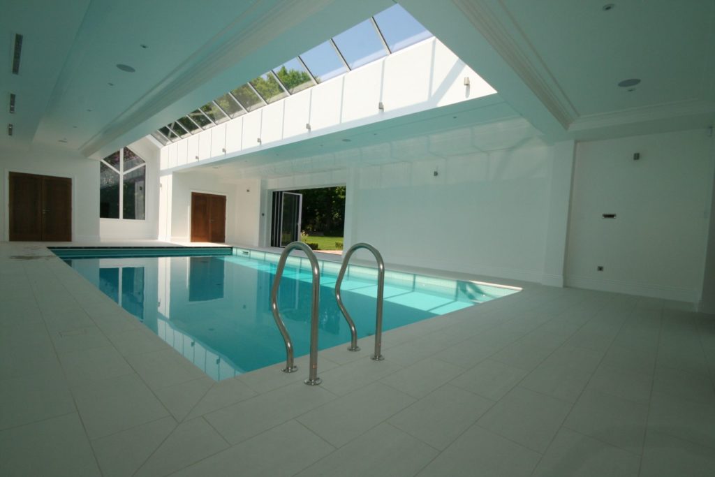 Muted tones and flush ivory surround in this pool with ivory mosaic tiles and automatic safety cover.