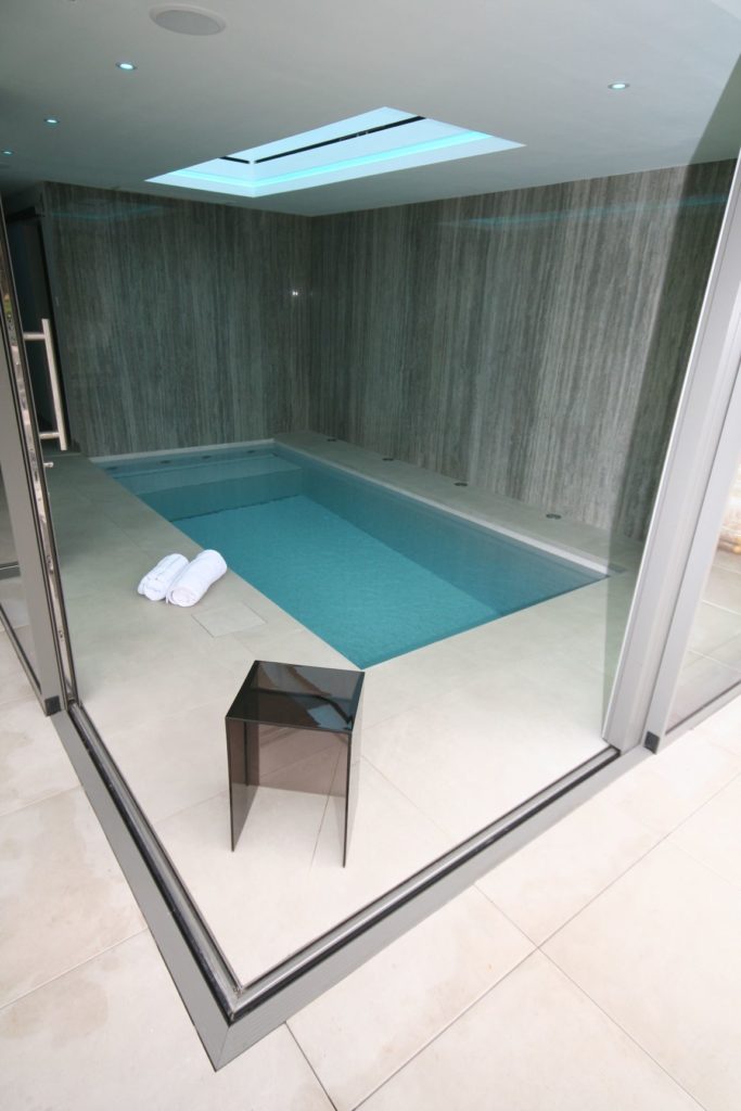 Small hydrotherapy pool with Daisy Dagen water treatment system for swimming in drinking water class pool water, a Fastlane counter current for training and a below bench housing for the automatic slatted cover, which also doubles up as a jetted lounger.