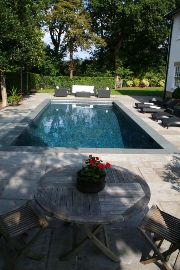 Charcoal tiles and an automatic safety cover in this Surrey pool